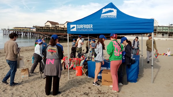 volunteers standing at surfrider tent for a beach cleanup